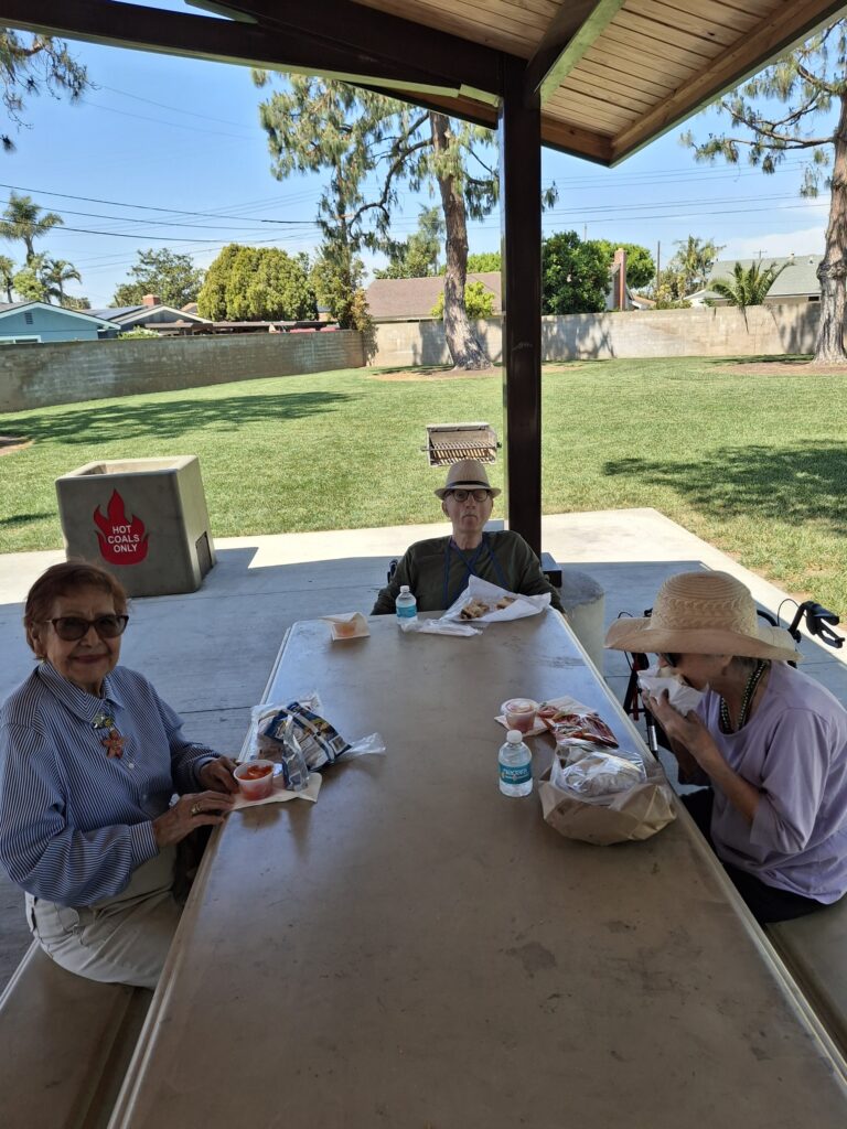 senior residents enjoying lunch together at the park